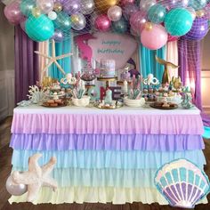 a table topped with lots of cake and balloons