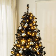 a small christmas tree with gold and silver ornaments