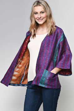 "Our Silk Kantha Kimono Jacket is handmade by women artisans in India using 100% silk up-cycled saris. Each piece is uniquely beautiful  and features exquisite hand stitching known as \"kantha\" that is done by women artisans in West Bengal, India, with indigo block print trim detail. Designed in a contemporary, elegant cut with different sari prints on each side and pockets, these handmade kimonos are reversible and each piece is truly a wearable work of art. One size fits most, comes in assorted prints and colors, 27\" length." Indigo Block Print, Kantha Kimono, High Neck Crop Top, West Bengal, Halter Crop Top, Kimono Jacket, Front Tie Top, Women Artisans, Tie Top