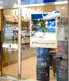 a window display with a plane in the background and an advertisement for we are pilots