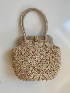 "Vintage Faux Raffia Handbag 1960s 70s Off White Bamboo Handle Free shipping  This handbag is perfect for your resort-wear or spring/summer wardrobe. It looks barely used. The inside is lined with cotton fabric and has one small open pocket. There is no brand label, but it does say \"Made in Japan\". The inside is a little dirty, but not bad at all. The outside has no flaws to note. It has a gold tone metal kiss closure and the handle is bamboo. It also has metal feet on the bottom to prevent wear and tear.  12\" wide by 6.5\" tall by 4.5\" deep. Handle has a 5\" drop" Vintage Brown Bags For Spring, Retro Beige Shoulder Bag For Spring, Vintage Straw Bag For Summer Vacation, Vintage Summer Straw Bag For Vacation, Vintage Summer Vacation Straw Bag, Retro Beige Shoulder Bag For Summer, Beige Retro Shoulder Bag For Summer, Vintage Summer Straw Bag In Natural Color, Vintage Summer Bag With Braided Handles