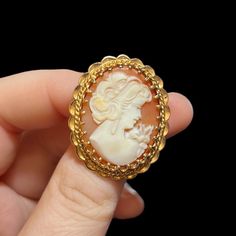 "Mid-century 14K gold cameo brooch. Circa 1960's. Genuine shell cameo set in a heavy 14K gold setting. 1.25\" inches long, 1.1\" inches wide. Marked on the pin stem. Depicts a beautiful young woman wearing long earrings and a dress with a large bow on her shoulder. The brooch is in excellent condition. Could be converted to a pendant. A rare find.  A stunning gift for that special someone. Pleasee contact me if you have any questions." Vintage Yellow Gold Oval Brooch, Vintage Cameo Brooch In Yellow Gold, Vintage Yellow Gold Cameo Brooch, Cameo Jewelry, Cameo Brooch, Large Bow, Young Woman, Long Earrings, Beautiful Earrings