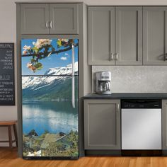 a refrigerator with an image of a lake and mountains on the door is shown in this kitchen