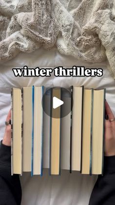 someone is laying in bed with two books on top of each other and the words winter thrillers above them