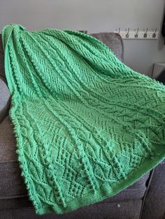 a green blanket sitting on top of a couch