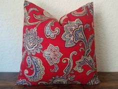 a red and blue pillow sitting on top of a wooden table