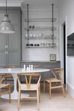 an image of a kitchen with grey cabinets and white tile on the wall above it