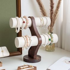 a wooden stand with bracelets and jewelry on it