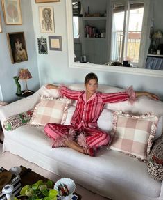 a woman sitting on top of a white couch