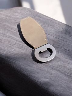 a metal object sitting on top of a wooden table next to a white cloth covered chair