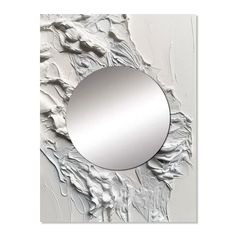 a round mirror hanging on the wall in front of a white background with silver paint