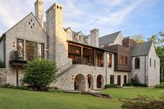 a large brick house sitting on top of a lush green field