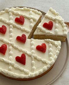 a cake with white frosting and red hearts on it