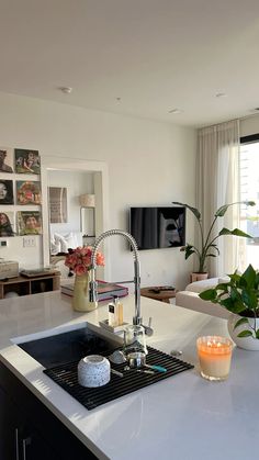 a kitchen with a sink, stove top and television in it's center island