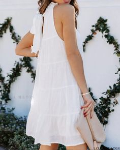 Bella Milton - Stylish Sleeveless Swing Dress with Frill Hem and Flowy Design White Sleeveless Tie-back Dress, White Sleeveless Dress With Tie Back, Flowy Sleeveless Halter Neck Dress For Spring, Flowy Sleeveless Dress For Garden Party, Flowy Sleeveless Sundress For Garden Party, Sleeveless Halter Dress For Summer Brunch, Vacation Sleeveless Dress With Tie Back, Sleeveless Spring Mini Dress With Tie Back, White Flowy Sleeveless Halter Dress