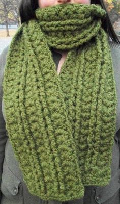 a woman wearing a green knitted scarf