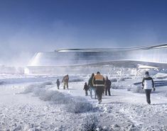 people are walking in the snow near a building with a curved roof and glass walls