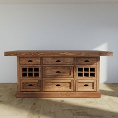 a wooden table with drawers on top of it in an empty room next to a white wall