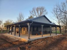 a large metal building sitting on top of a dirt field