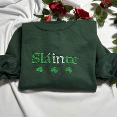 Stay warm and look stylish with this unique Slainte embroidered at the center of the chest This piece of clothing is perfect for any casual occasion. ST. Patrick's day funny shamrock embroidered crewneck . the high-quality fabric keeps you warm and comfortable, while the intricate embroidery brings a touch of elegance and charm to any ensemble. Whether you're out and about or just lounging at home, this sweatshirt is sure to make you stand out from the crowd. The sweatshirt also features a classic crew neckline and long sleeves for a timeless look. It's available in a range of sizes and colors, so you're sure to find the perfect one to suit your style. Plus, it's easy to care for, making it the perfect addition to your wardrobe. Product Benefits: * Stylish and fashionable  * Comfortable an Green Casual Hoodie With Custom Embroidery, Casual Green Hoodie With Custom Embroidery, Casual Crew Neck Hoodie As Gift, Embroidered Logo Long Sleeve Sweatshirt, Embroidered Logo Sweatshirt As A Gift, Long Sleeve Sweatshirt With Embroidered Logo Gift, Gift Sweatshirt With Embroidered Text And Long Sleeves, Casual Sweatshirt With Embroidered Graphics As Gift, Casual Sweatshirt With Embroidered Text For Gift