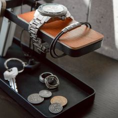 a watch sitting on top of a table next to keys