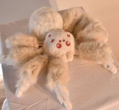 a stuffed animal laying on top of a white sheet