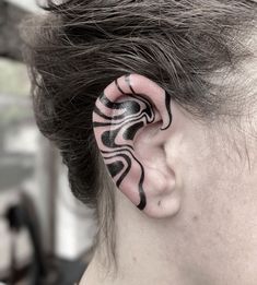 a woman with a black and white tattoo behind her ear