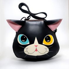 a black purse with a cat's face painted on it