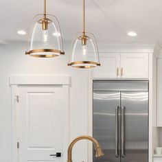 a kitchen with two lights hanging from the ceiling