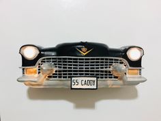 an old model car with the number 55 caddy on it's front grill