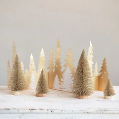 small christmas trees are lined up on a table