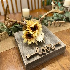 a sunflower is sitting on top of a wooden box with the word love spelled out