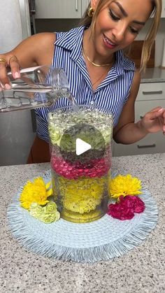 a woman pouring water into a vase filled with flowers