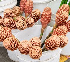 several white buckets filled with different types of flowers