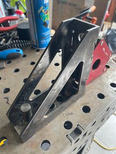 a metal object sitting on top of a workbench in a garage with tools nearby