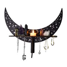 a wall mounted shelf with jewelry hanging from it's sides and a candle on top