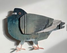 a bird made out of cardboard sitting on top of a table