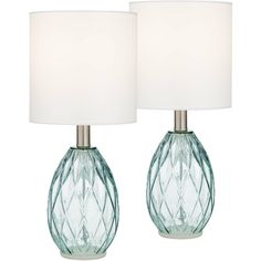 two green glass lamps with white shades on them