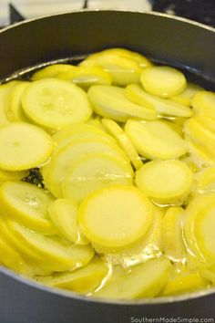 sliced potatoes are being cooked in a pan on the stove top with oil over them