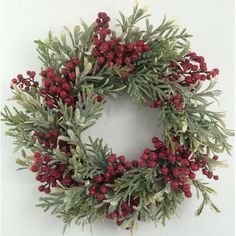 a christmas wreath with red berries and green leaves on a white background, ready to be hung