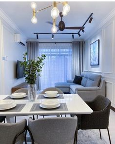 a dining room table with plates and bowls on it, in front of a couch