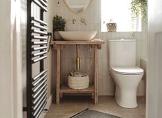 a white toilet sitting next to a sink in a bathroom on top of a wooden table