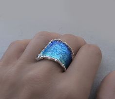 "The sweetness of calming blues, an ocean of life wrapped around your finger, Jewelersoul's contemporary Wrap Wave Ring is coated with layers of blue enamel over sterling silver. The modern ring is for true ocean lovers. Please note that Jewelersoul's unique handmade process may result in subtle variations in color and metal growth. Details: Weight: 8.2 g Width: 24 mm = 0.94\" Size US Available: 7 3/4\" US. Other sizes: please tell me and I would make the you size ring. Follow me www.facebook.co Blue Sterling Silver Fusion Rings, Fusion Style Blue Sterling Silver Rings, Unique Blue Enamel Ring, Blue Fusion Style Rings As A Gift, Wide Silver Ring, Handmade Silver Jewelry, Silver Ring For Women, Lace Ring, Ocean Jewelry