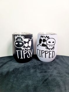 two black and white cups sitting on top of a table