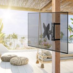 an outdoor living area with white furniture and palm trees in the background on a sunny day