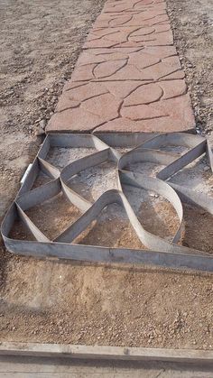 a long stone path in the middle of a dirt field