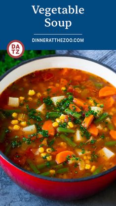 a red bowl filled with vegetable soup on top of a table