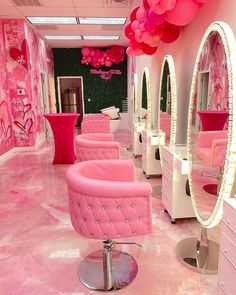 a room with pink furniture and balloons hanging from the ceiling