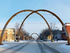 an arch in the middle of a snowy street