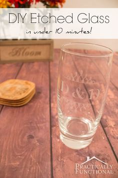 a glass with the words diy etched glass in under 10 minutes is sitting on a wooden table